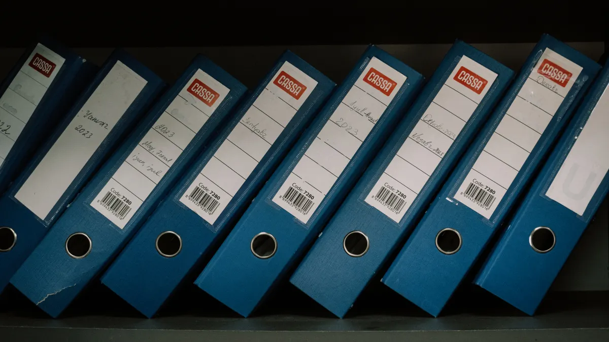 Row of blue ring binders on a shelf
