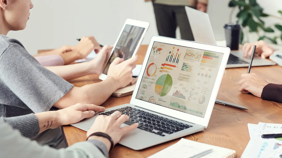 people reviewing analytics on a laptop in a meeting