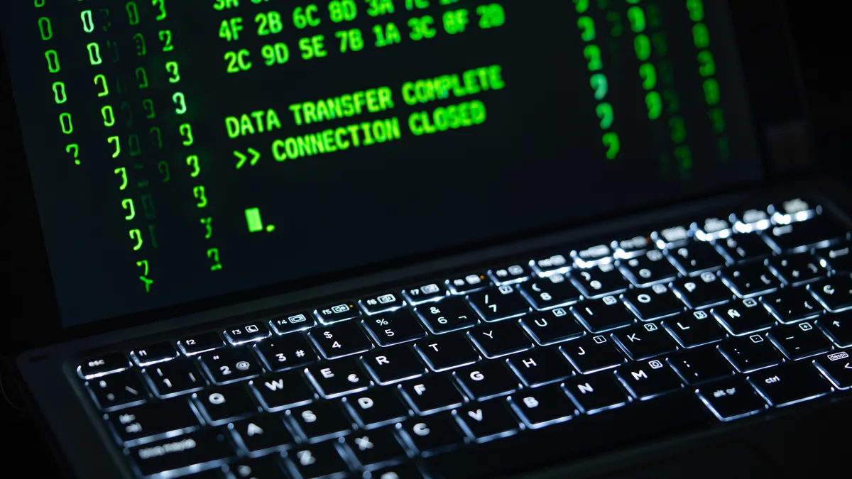 SaaS Security, Compliance, and Trust — The Complete Guide Laptop showing green code and data
