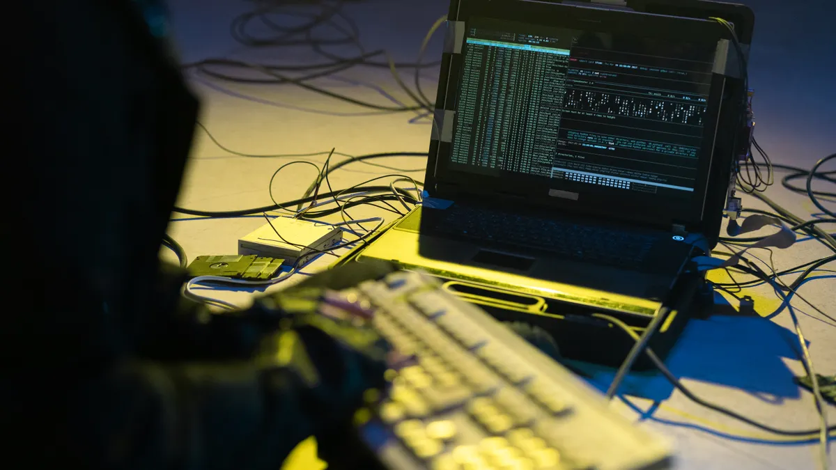SaaS Security, Compliance, and Trust — The Complete Guide Laptop on desk with connected cables and code