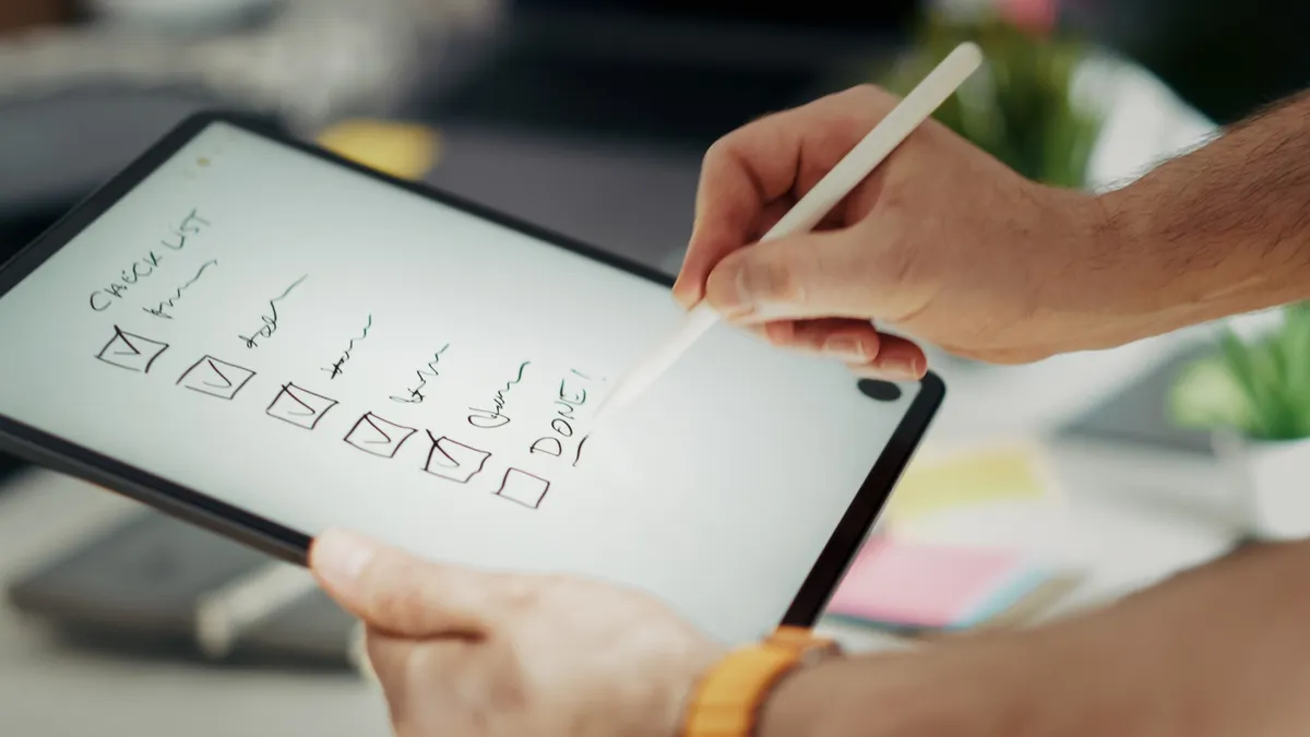 stylus marking a checklist on a tablet